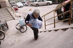高美運(yùn)正在吃力地搬運(yùn)桶裝水