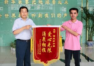 痊愈后的豆洪波將錦旗送到“2007——生命救助大行動”總策劃徐寧手中